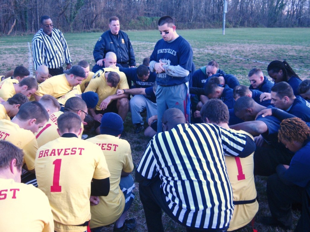 Hyattsvilleʼs police officers and firefighters pray together following the Heroes Bowl on December 3. 