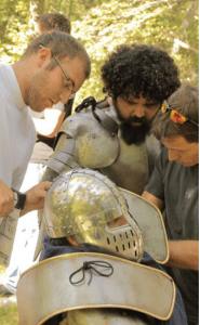 For his latest project, a web series that debuted on  March 10, filmmaker Francis Abby recruited fellow St. Jerome and DeMatha grad Matt Creger.  Creger, at left, helps adjust a helmet for one of the actors. Photo courtesy Francis Abbey.