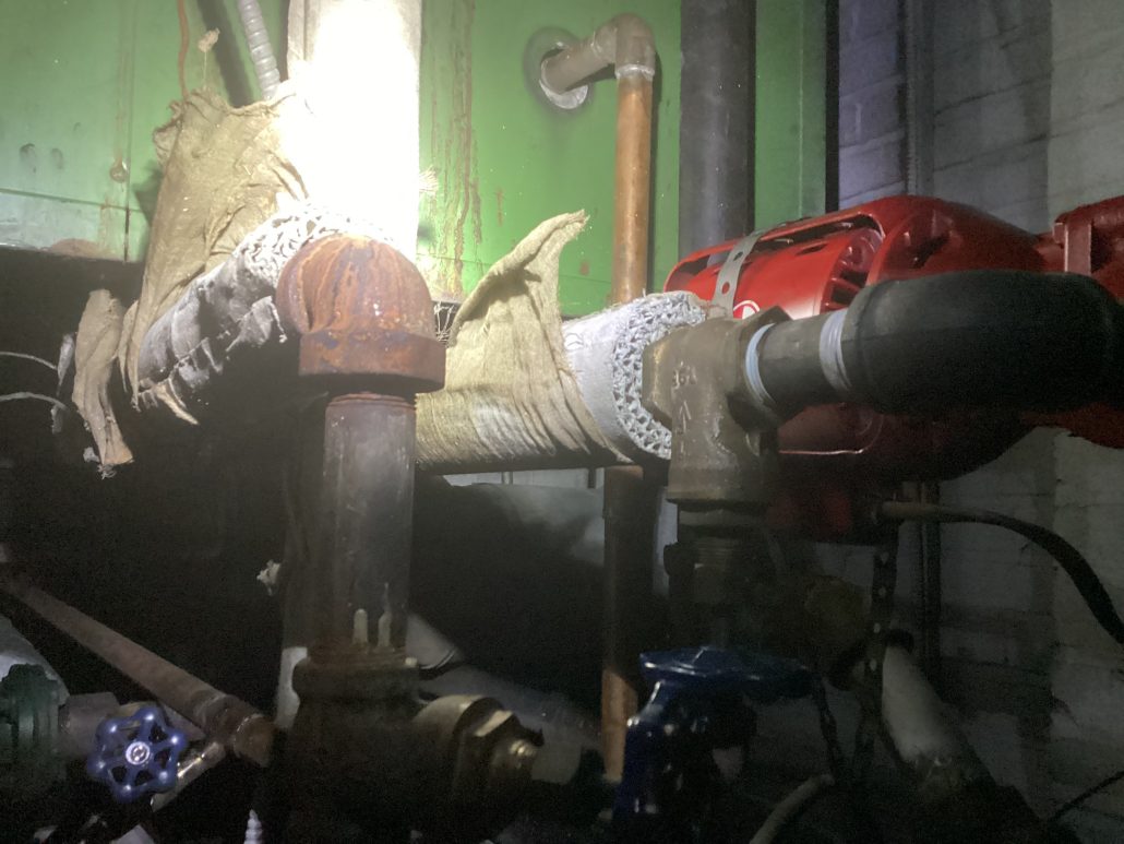Asbestos insultation crumbling off of a homeowners boiler boiler e1702571986406