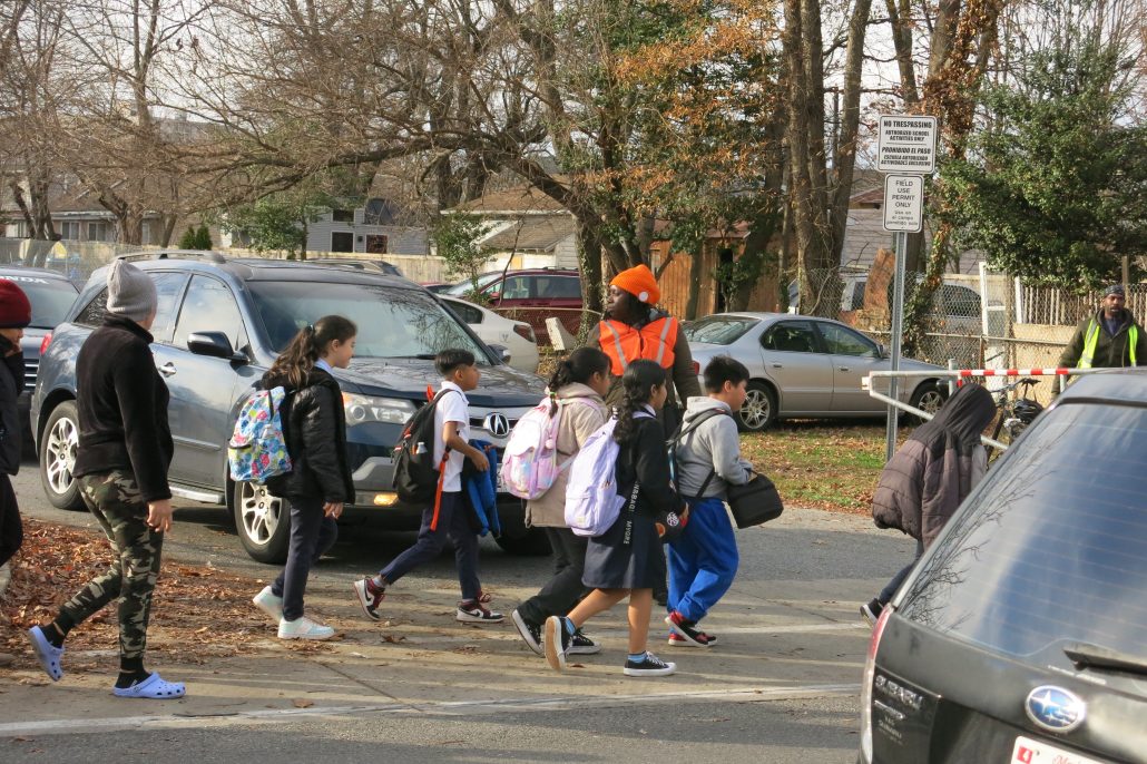 Staff directing traffic at a PG school without crossing guards
